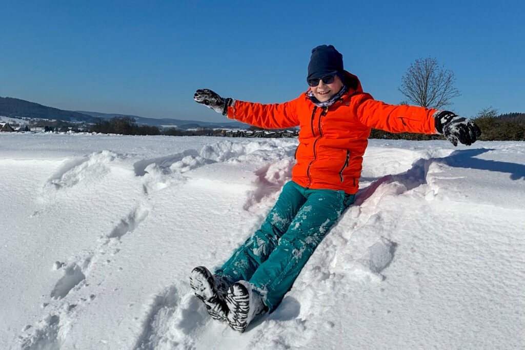Eine Person sitzt im Schnee.
