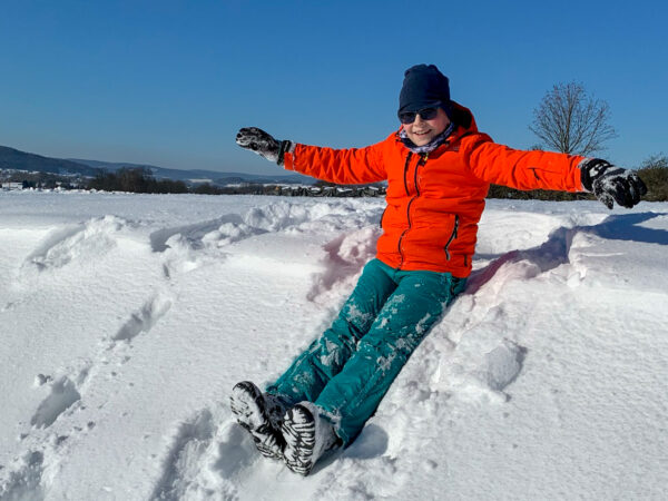 Eine Person sitzt im Schnee.